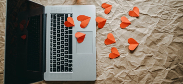 Dator med pappershjärtan utspridda